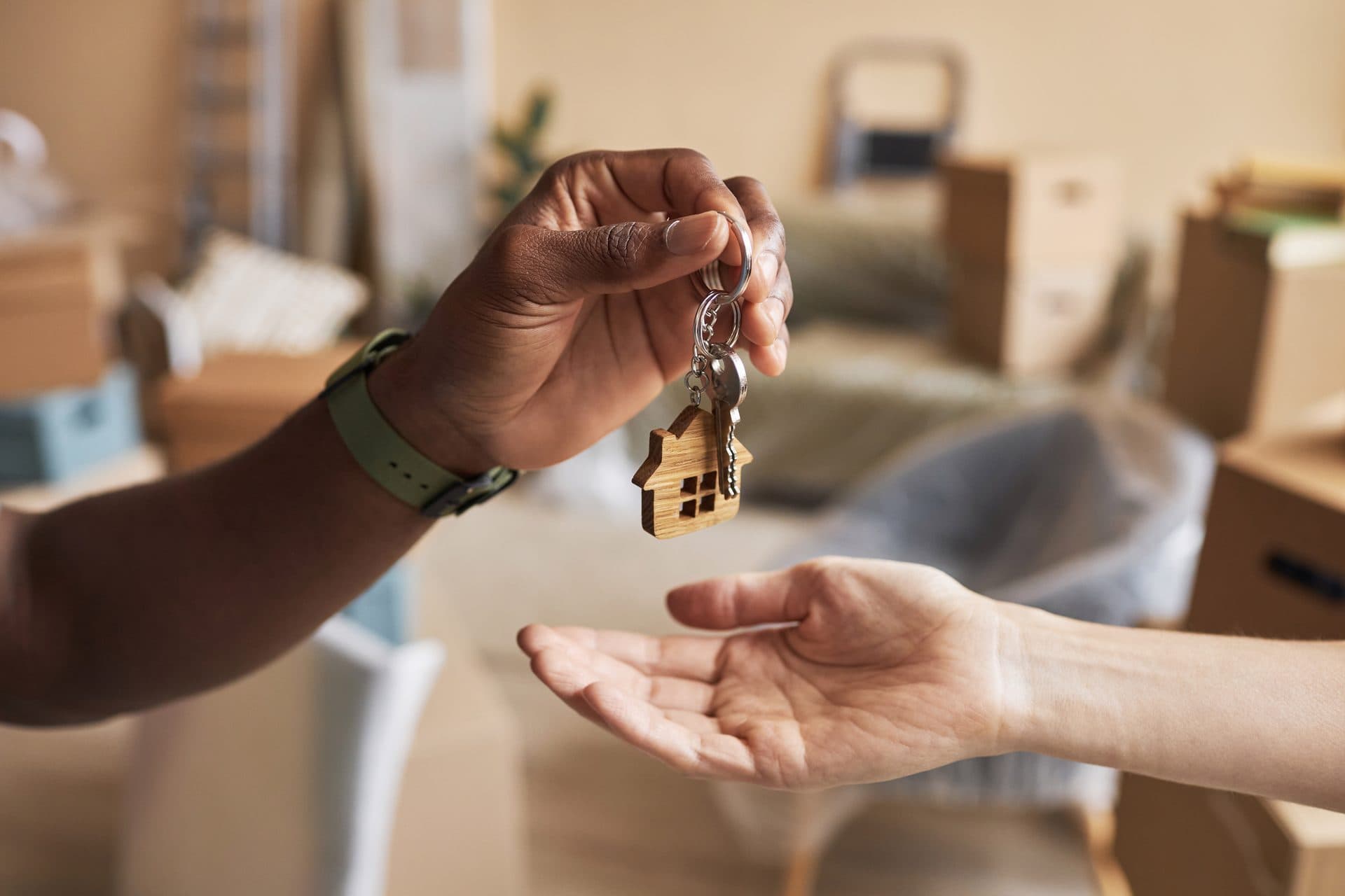 A house key being handed to an investor's open palm